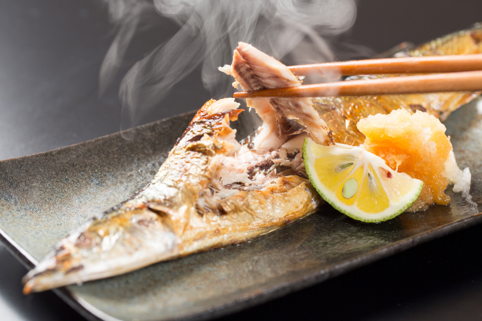 Cá nướng Sanma nóng hổi chuẩn vị khi ăn kèm củ cải nhuyễn và chanh vắt phía trên lớp da 