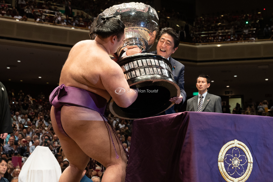 Một võ sĩ Sumo nhận chiếc cúp vo địch từ Thủ tướng Nhật Shinzo Abe.